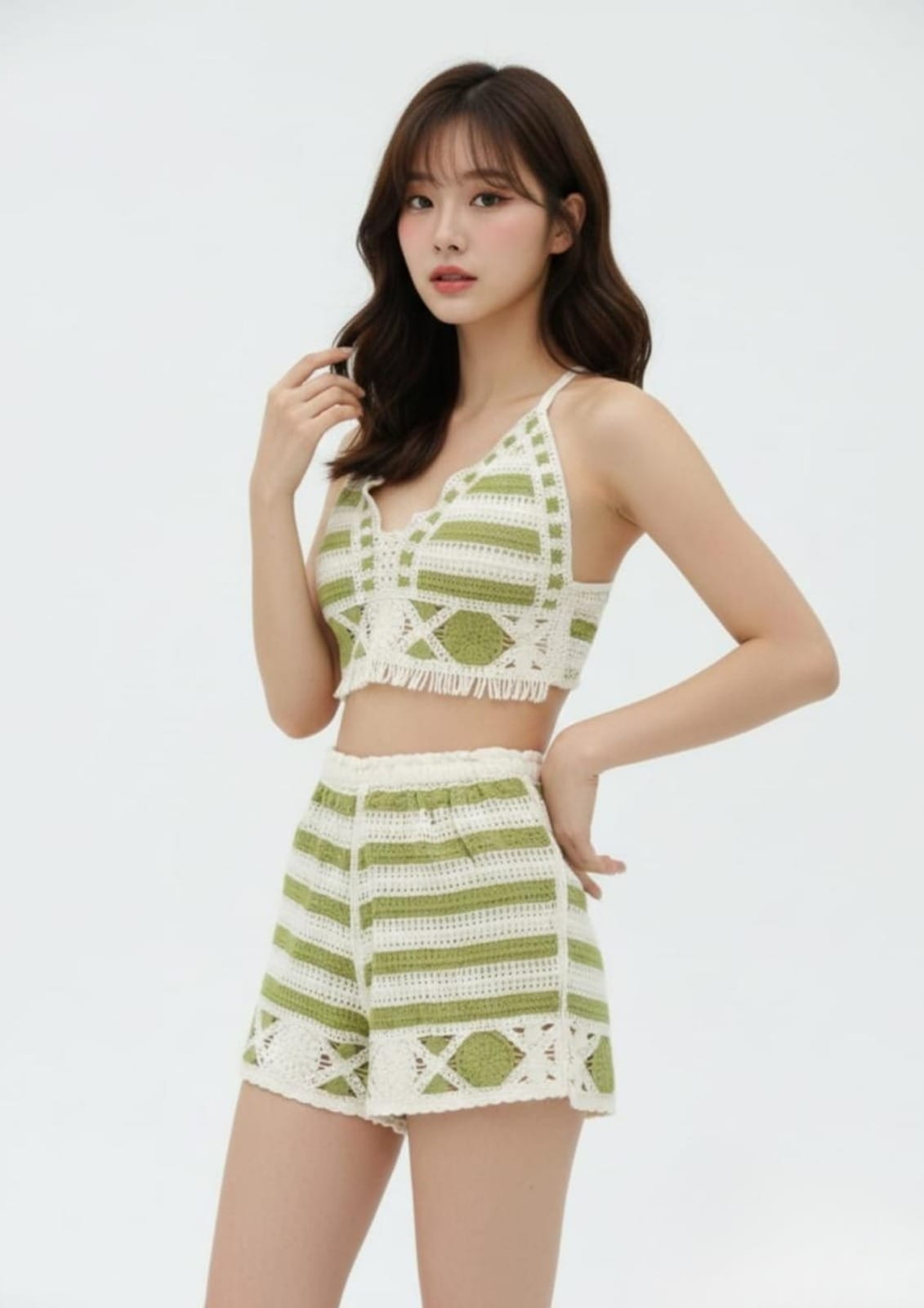 Woman wearing a green and white crochet outfit on a light gray background